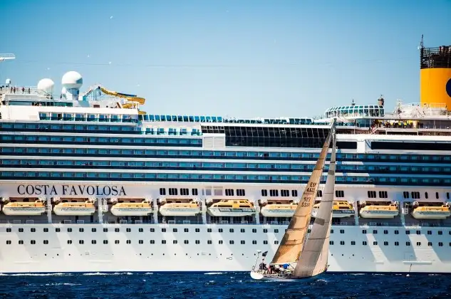 Un participante en la Sail Racing PalmaVela junto a un transatlántico (Foto: Tomàs Moyà)